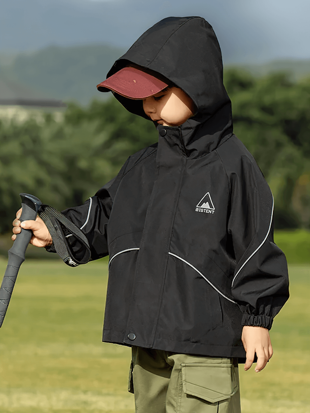 Child wearing Outdoor Waterproof Children's Windbreaker Jacket - SF3571 in a field, perfect for rainy day adventures.